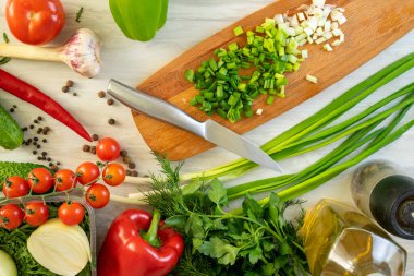 Bıçak ve ahşap kesme tahtasının yüksek açılı natürmort manzarası Taze otlar ve çeşitlilikle çevrili