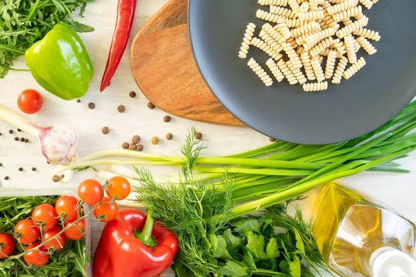 üzerinde siyah servis tabağı, patlıcan, biber ve domates penne makarna. fesleğen ile süslenmiş.