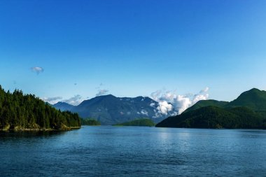 Turkuaz sular ve alçak bulutlar Pasifik Okyanusu 'nda, Bc, Kanada' da sabah güneşiyle aydınlanıyor.