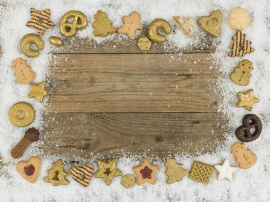 Beyaz kar ve ahşap zemin üzerinde noel kurabiyeleri koleksiyonu