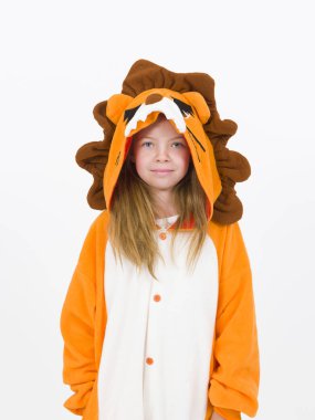 pretty blonde girl in cozy lion costume posing in front of white wall