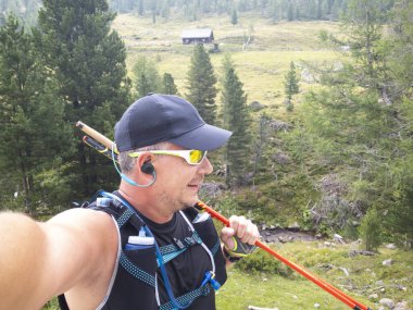 Avusturya 'daki Carinthian dağlarında spor giyimli koşan adamın selfie' si. 