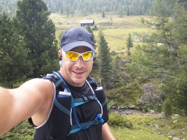 Avusturya 'daki Carinthian dağlarında spor giyimli koşan adamın selfie' si. 