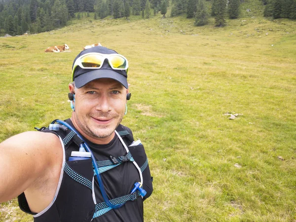 selfie of trail running man wearing sportswear in carinthian mountains, Austrian