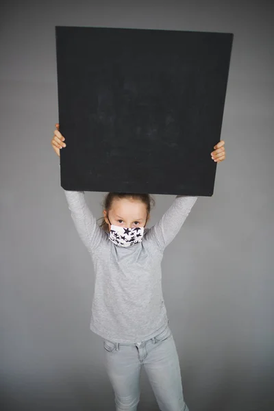 Girl Medical Protective Mask Holding Blank Board Grey Background — Stock Photo, Image