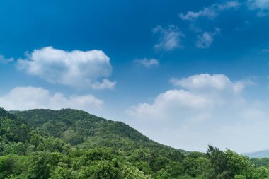 Dağlar ve ağaçlar güzel mavi gökyüzü ve sabah bulutları