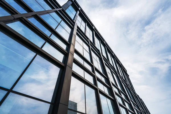 Wolken spiegeln sich in Fenstern moderner Bürogebäude — Stockfoto