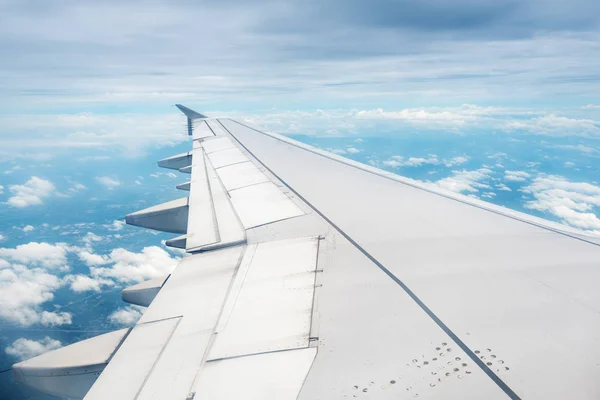 Nubes y cielo visto a través de la ventana de un avión — Foto de Stock