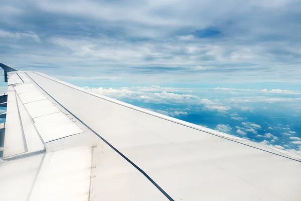 Nubes y cielo visto a través de la ventana de un avión — Foto de Stock