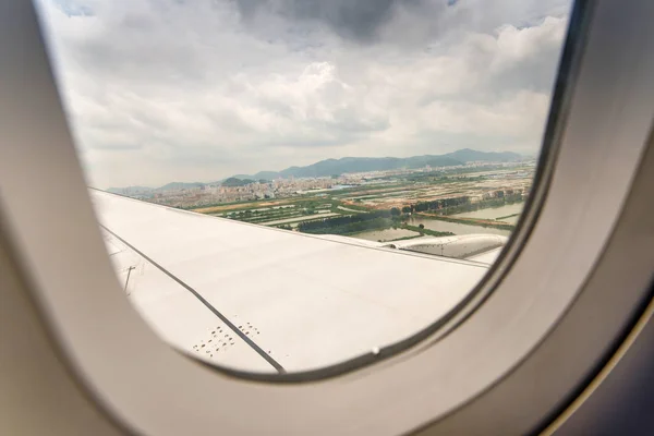 Nubes y cielo visto a través de la ventana de un avión — Foto de Stock