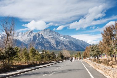 Buz gibi mavi gökyüzü altında karlı yol
