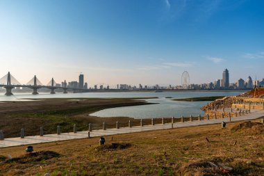 Sıcak, güneşli bir günde güzel, beyaz, kumlu bir plajın üzerinde modern, metropoliten bir şehir kulesinin uzun gökdelenleri..