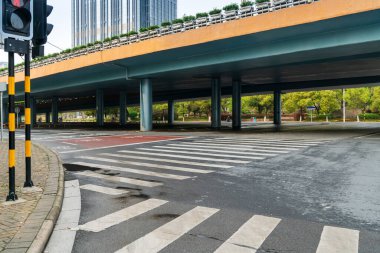 Şehirdeki üst geçidin altında beton yapı ve asfalt yol alanı
