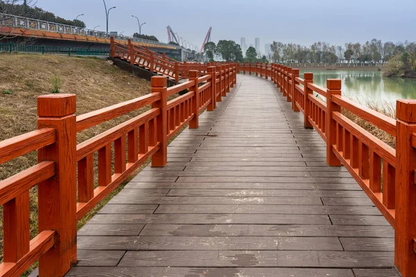 都市公園内の小さな川にかかる木製の橋 — ストック写真