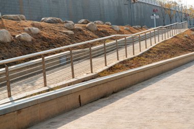 Tekerlekli sandalye rampası, merdivenlere ek olarak veya onun yerine eğimli bir uçak, engelli insanlar için eğimli yürüyüş yolu, bebek arabalarını iten insanlar, paslanmaz çubuklu arabalar düşmesini önlemek için