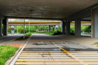 Şehirdeki üst geçidin altında beton yapı ve asfalt yol alanı