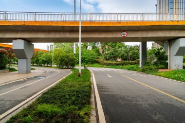 Şehirdeki üst geçidin altında beton yapı ve asfalt yol alanı