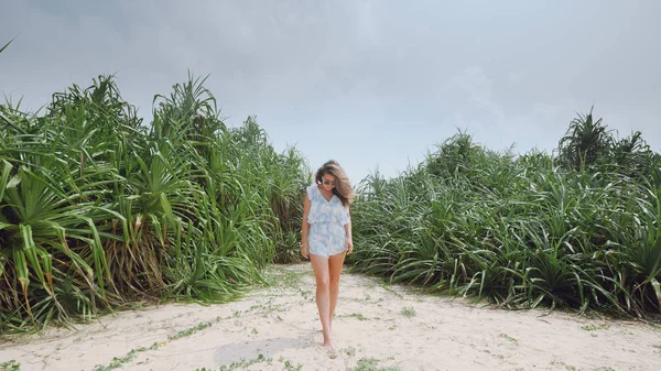 Chica en la playa en el fondo de las plantas tropicales — Foto de Stock