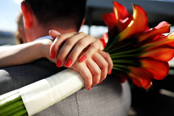 Röd bukett i händerna på bruden — Stockfoto