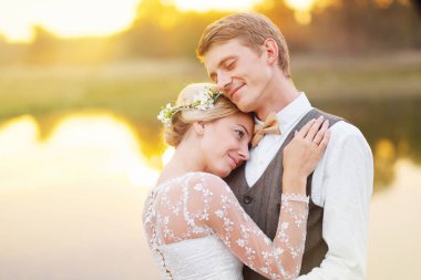 Fon karşı düğün kıyafetleri içinde birkaç gün batımı, gelin ve damat sahasında