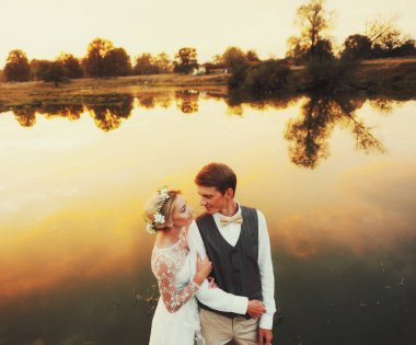 Fon karşı düğün kıyafetleri içinde birkaç gün batımı, gelin ve damat sahasında