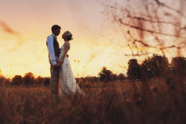 Fon karşı düğün kıyafetleri içinde birkaç gün batımı, gelin ve damat sahasında. 