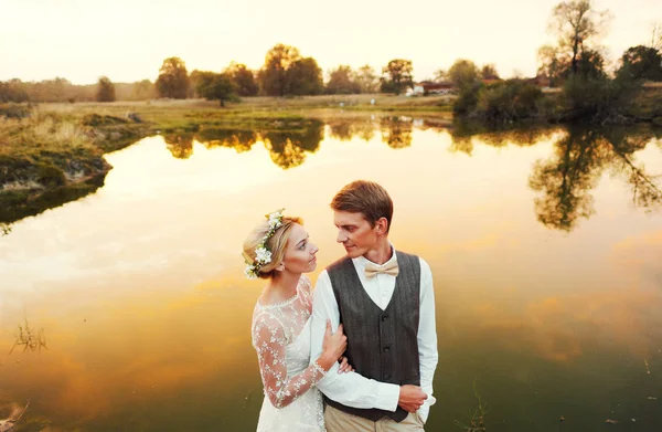 Couple in wedding attire against the backdrop of the field at sunset, the bride and groom. — Stock Photo, Image