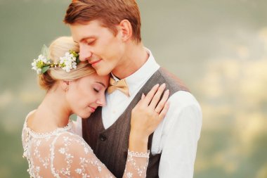 Gelin ve Damat Düğün töreni sonrası gölün yanında dur. Yeni evli gülümseyen, onlar mutlular. Fotoğraf sıcak beceremedim. Yakın çekim.