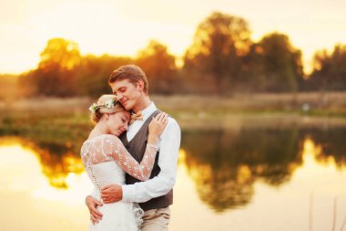 Düğün birkaç arka plan karşı günbatımı güneş suya portresi. Arka planda bir göl