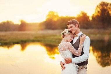 Düğün birkaç arka plan karşı günbatımı güneş suya portresi. Arka planda bir göl