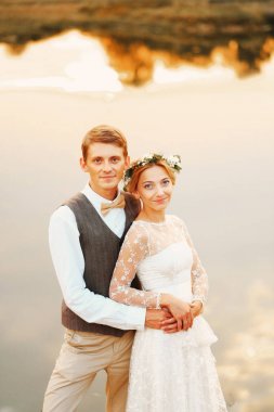 Yeni evli bir göl önünde stand