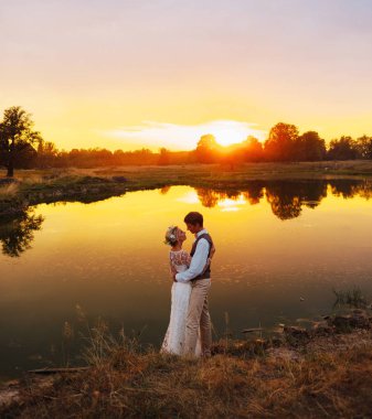 Fon karşı düğün kıyafetleri içinde birkaç gün batımı, gelin ve damat sahasında. 