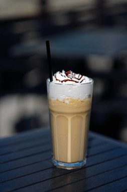 Latte macchiato kremalı çörek karanlık bir tablo ile uzun bardak kahve