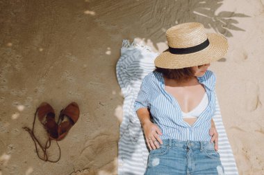 Bir kızın bir şapka kum üzerinde güneşlenme yukarıdan görüntülemek