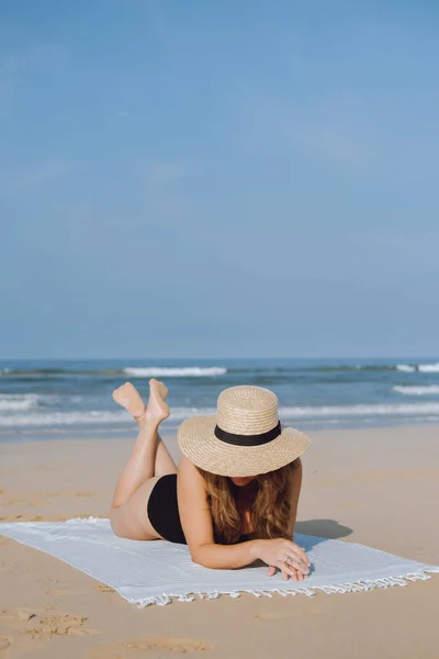 Jonge vrouw in een hoed op het strand in de buurt van de Oceaan — Stockfoto
