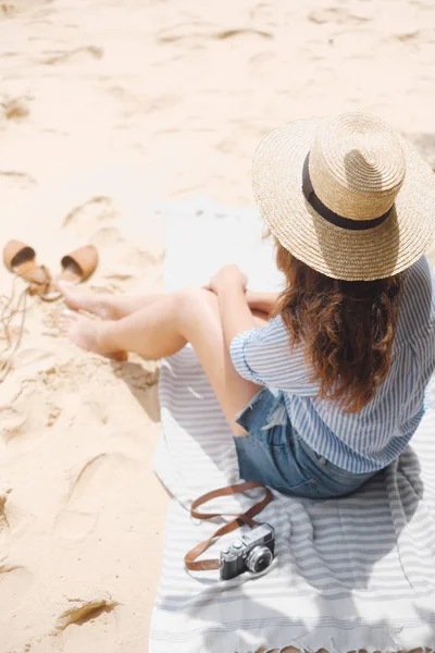 Девушка сзади сидит на песке — стоковое фото