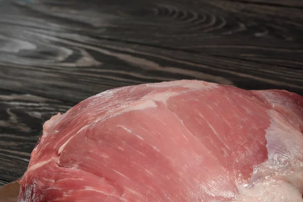 Raw pork shoulder close-up. Pork tenderloin on paper on a dark background