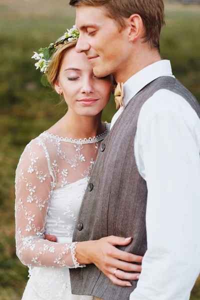 Les mariés se tiennent sur le fond de l'arbre, après la cérémonie de mariage. Les jeunes mariés sourient, ils sont heureux . — Photo