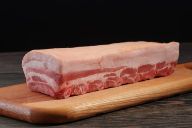 Domuz loin kaburga ve karanlık bir arka plan üzerinde bir kesme tahtası üzerinde yağ ile taze çiğ tüm raf. 