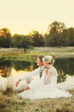 Göl günbatımı, gelin ve damat, düğün kıyafetleri fon karşı içinde mutlu çift.