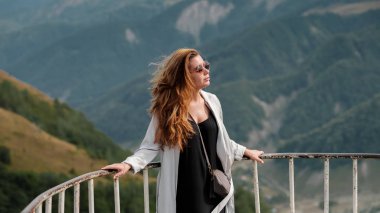 Genç kadının Gudauri, Gürcistan'daki Kafkas dağlarının görünümü. Gözlük ve uzun saçlı bir kızla