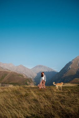 Bir kız ile bir köpek dağlarda yürüyüş 