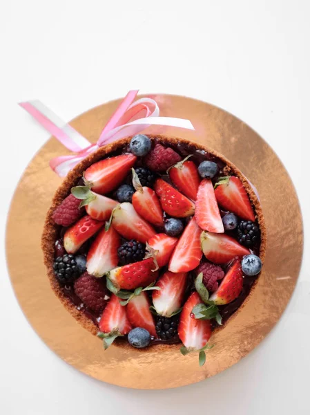 Cake on a stand, assorted fresh berries. Salad of strawberries, blueberries and raspberries.