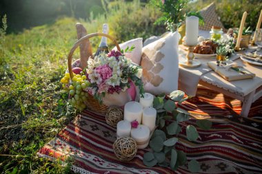 Zarif ahşap masa ile okaliptüs ve çiçekler, porselen tabak, bardak, peçete ve çatal bıçak takımı rustik tarzda dekore edilmiş