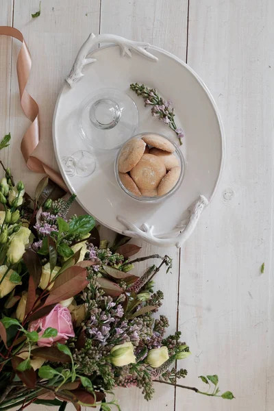 A beautiful cookie on a platter. Flowers in the background — Stock Photo, Image
