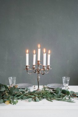 Masanın üstünde mumlar yanan ile gümüş avize
