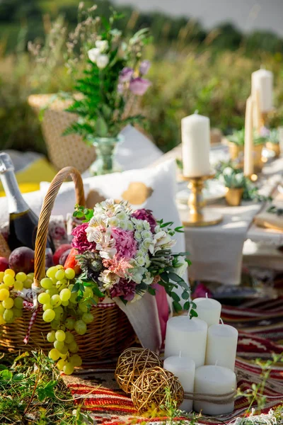 Cesta de mimbre picnic con fruta fresca, flores en el fondo de la naturaleza camping . — Foto de Stock