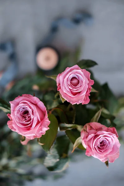 Rosa rosor, eukalyptus och spole med band — Stockfoto