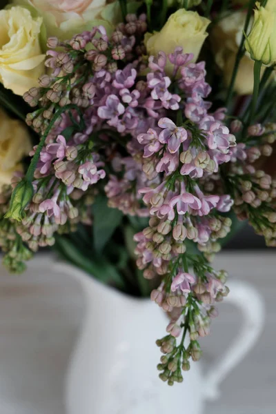 Lilac in a bouquet of flowers in a jug — Stock Photo, Image