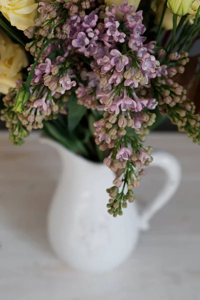 Lilac in a bouquet of flowers in a jug — Stock Photo, Image